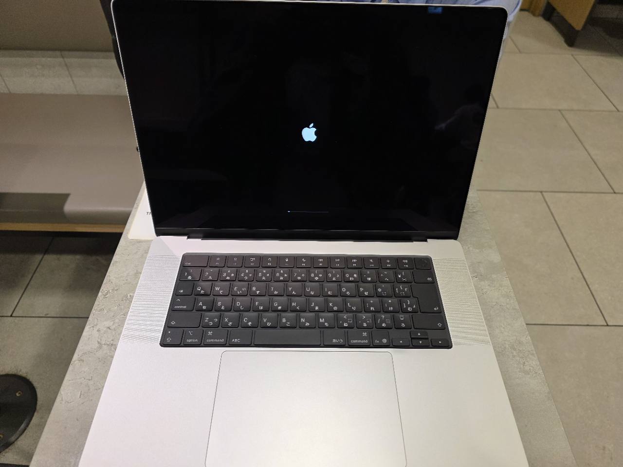Appleロゴが表示された起動中のMacBook Proと、日本語配列のキーボード